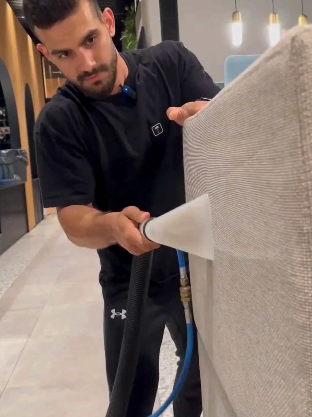 טכנאי Factory Clean מבצע ניקוי ריפודים מקצועי לריהוט בסביבת משרד אצל לקוח עסקי